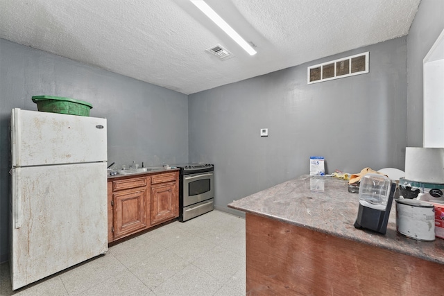 kitchen with stainless steel electric range, a textured ceiling, sink, and white refrigerator