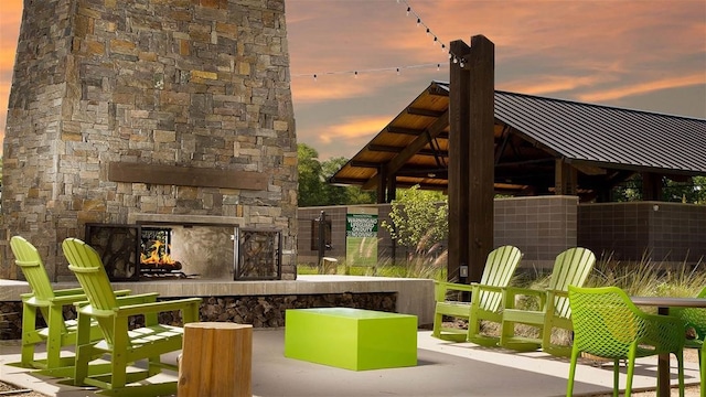 patio terrace at dusk with an outdoor stone fireplace