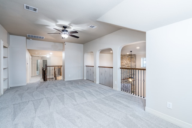 spare room with ceiling fan and light carpet