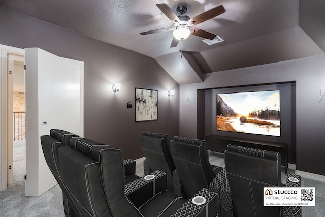 carpeted cinema room featuring lofted ceiling, ceiling fan, and a textured ceiling