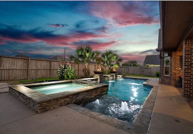 pool at dusk with pool water feature and an in ground hot tub