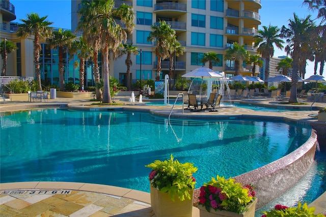 view of swimming pool featuring pool water feature and a patio