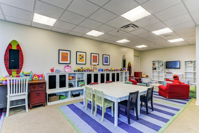 rec room featuring a paneled ceiling and light carpet