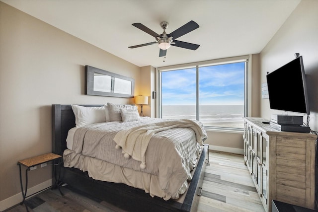 bedroom featuring access to exterior, light wood finished floors, baseboards, and ceiling fan
