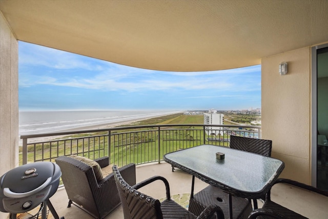 balcony featuring a water view and a beach view