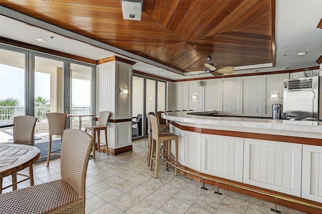 kitchen with built in fridge, ceiling fan, white cabinetry, and wood ceiling