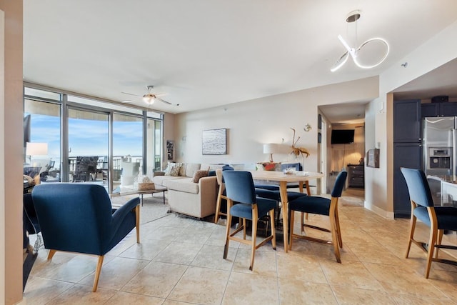 dining area with a wall of windows, a ceiling fan, and light tile patterned floors