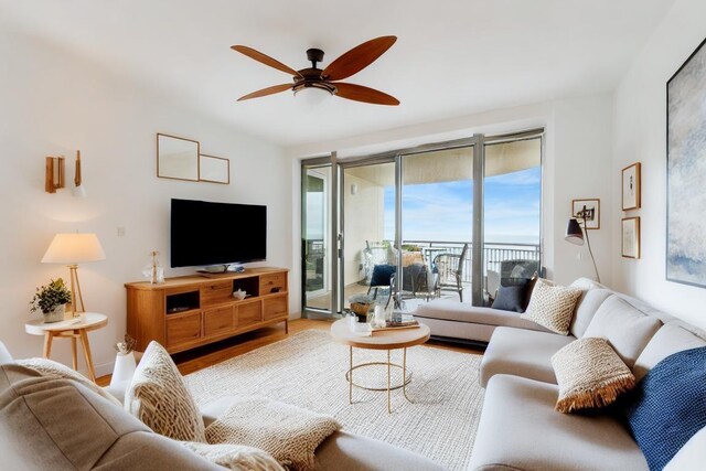 living area with wood finished floors and a ceiling fan