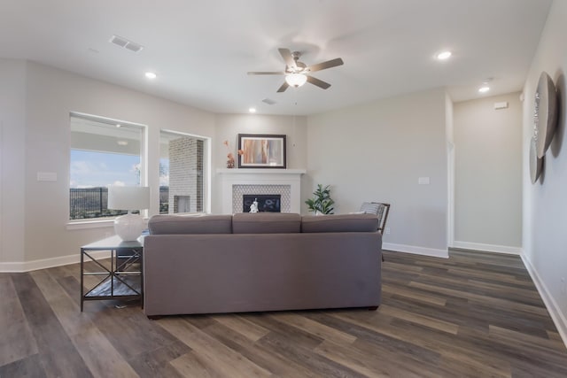 living room with a fireplace, dark hardwood / wood-style floors, and ceiling fan