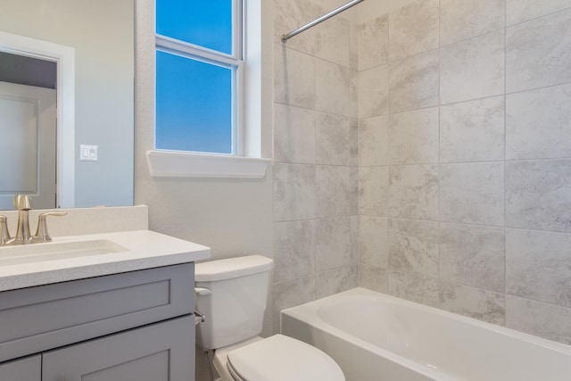 full bathroom with vanity, tiled shower / bath, and toilet