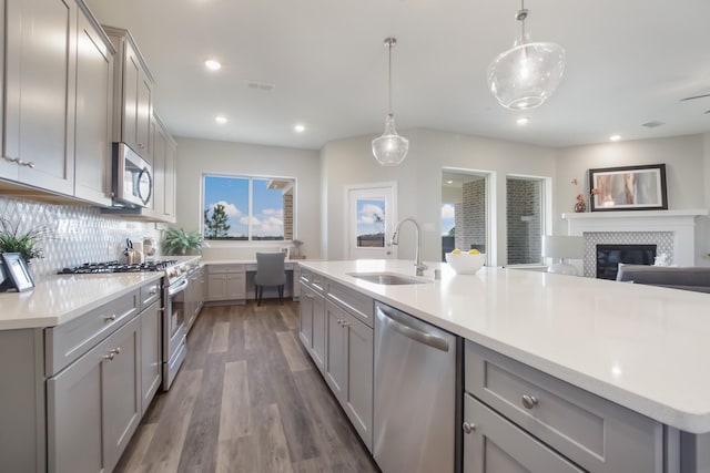 kitchen featuring gray cabinets, appliances with stainless steel finishes, sink, and decorative light fixtures