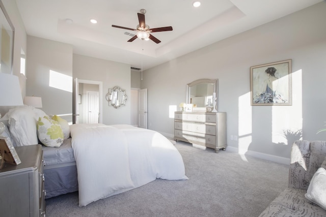 bedroom featuring a raised ceiling, ceiling fan, and carpet flooring