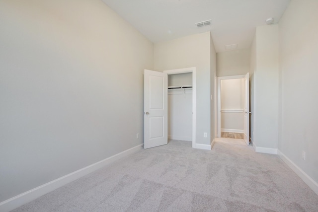 unfurnished bedroom featuring a towering ceiling, light carpet, and a closet