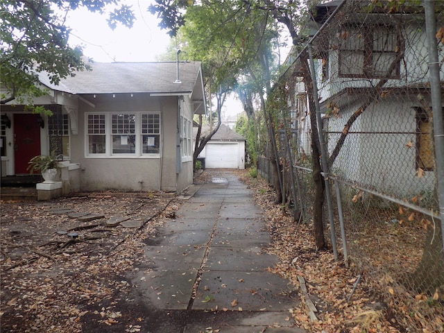 view of side of home featuring a garage and an outdoor structure