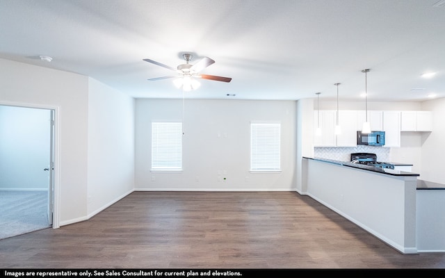 kitchen with ceiling fan, hanging light fixtures, hardwood / wood-style floors, range, and white cabinets