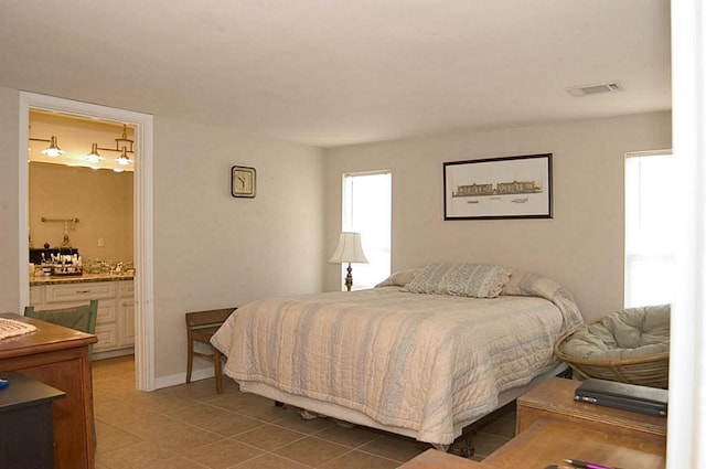 bedroom featuring tile patterned flooring and ensuite bath