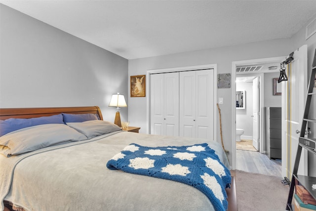 bedroom with light colored carpet, a textured ceiling, and a closet