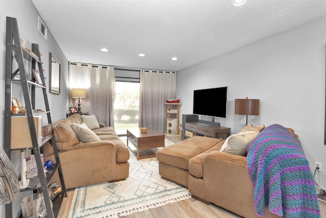 living room with a textured ceiling and light hardwood / wood-style flooring