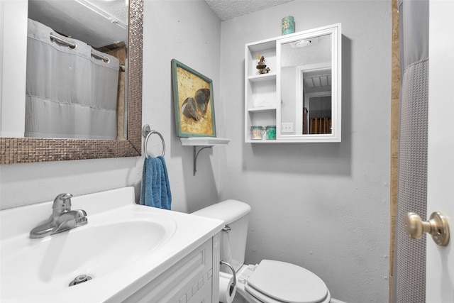 bathroom featuring vanity, walk in shower, a textured ceiling, and toilet