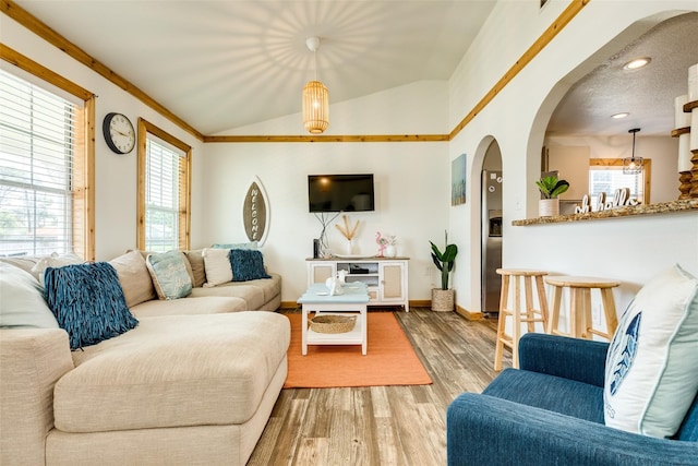 living room featuring ornamental molding, light hardwood / wood-style flooring, and lofted ceiling