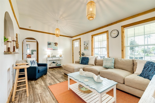 living room featuring hardwood / wood-style flooring, vaulted ceiling, and ornamental molding