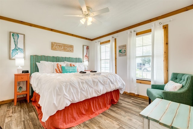 bedroom with hardwood / wood-style flooring, ceiling fan, and crown molding