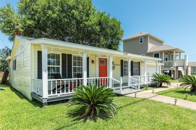 2114 57th St, Galveston, TX 77551 - view of front of home with a porch, an attached garage, and a front lawn