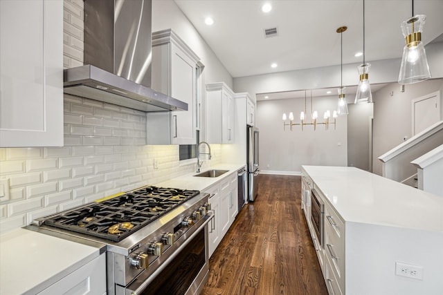 kitchen featuring dark hardwood / wood-style flooring, pendant lighting, high end appliances, wall chimney exhaust hood, and white cabinetry