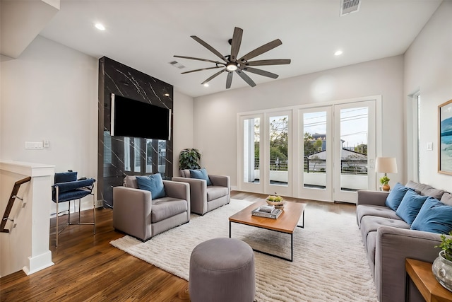 living room with dark hardwood / wood-style flooring and ceiling fan