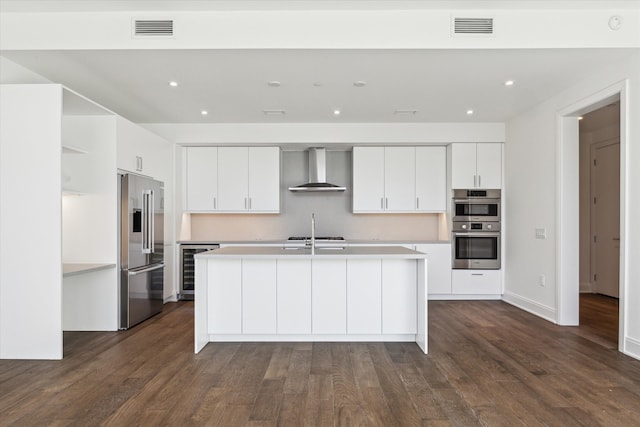 kitchen with wall chimney exhaust hood, dark hardwood / wood-style floors, and stainless steel appliances