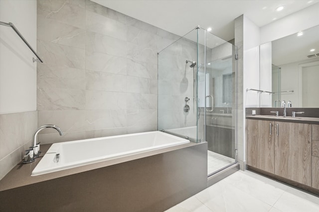 bathroom featuring vanity, independent shower and bath, and tile walls