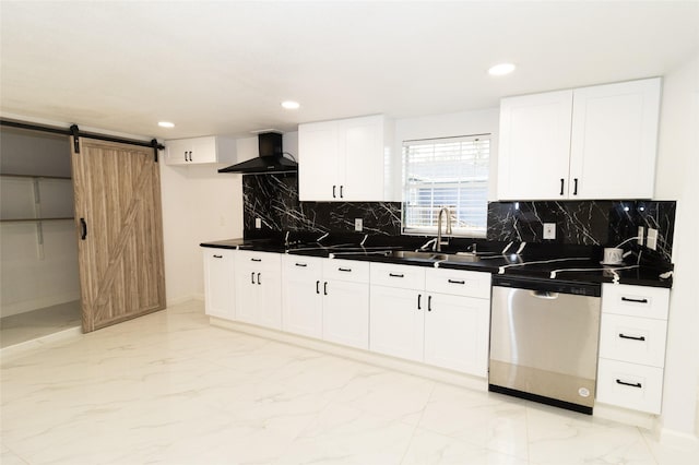 kitchen featuring white cabinetry, dishwasher, wall chimney exhaust hood, a barn door, and backsplash