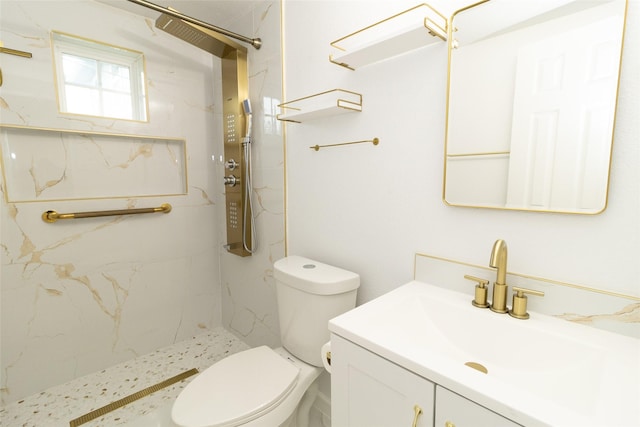 bathroom with vanity, toilet, and a tile shower