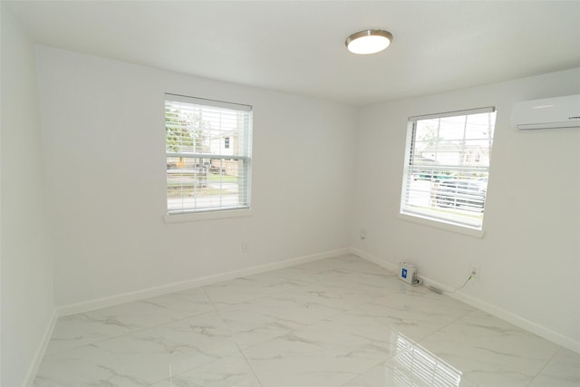 spare room featuring a healthy amount of sunlight and a wall mounted air conditioner