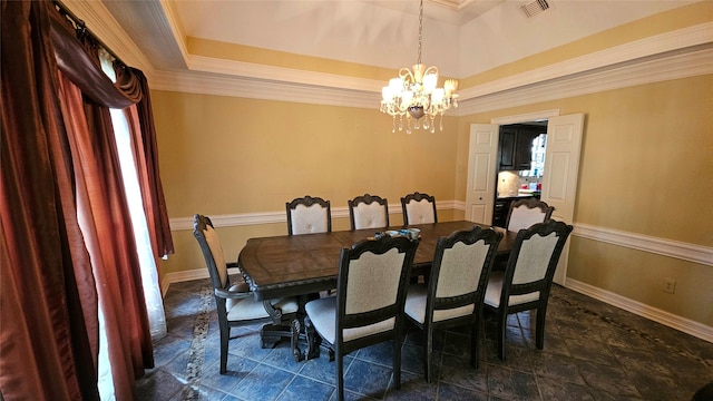 dining room featuring a tray ceiling, ornamental molding, and a notable chandelier