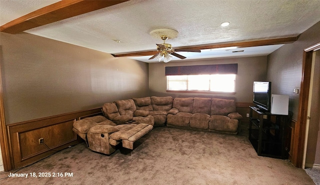 carpeted living room featuring ceiling fan, a textured ceiling, and beam ceiling