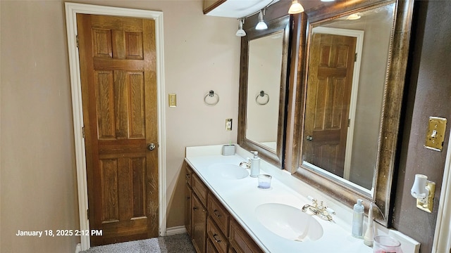 full bathroom with double vanity, baseboards, and a sink