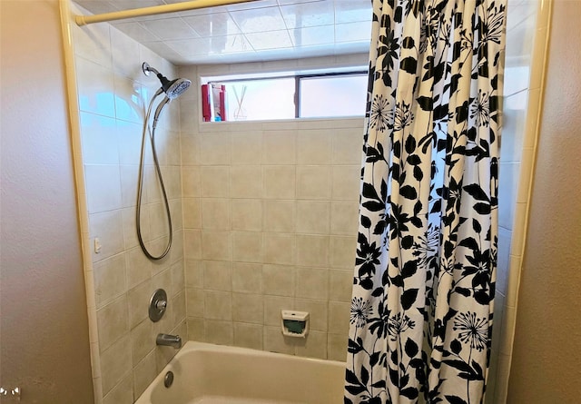 full bathroom with shower / tub combo and a textured wall