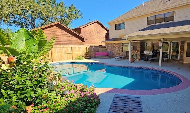view of pool with fence, area for grilling, a fenced in pool, and a patio area