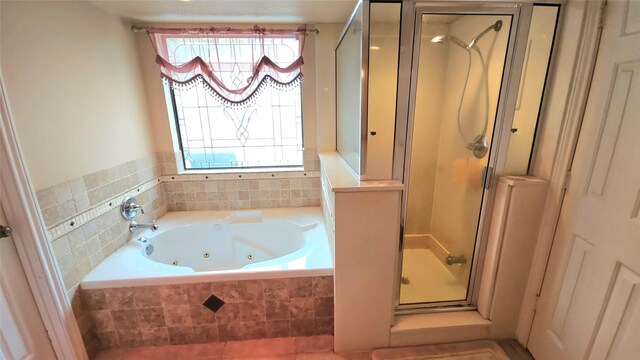 bathroom featuring a whirlpool tub, a shower stall, and a wealth of natural light