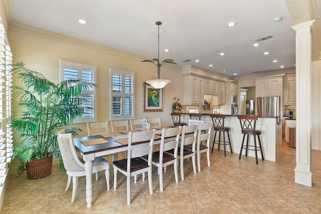 dining room with ornate columns, light tile patterned floors, and crown molding