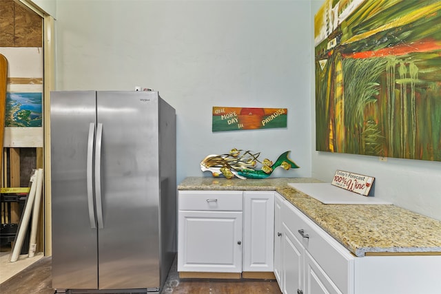 kitchen featuring stainless steel refrigerator and white cabinetry