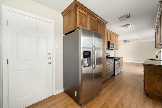 kitchen featuring ceiling fan, light hardwood / wood-style flooring, stainless steel appliances, and sink