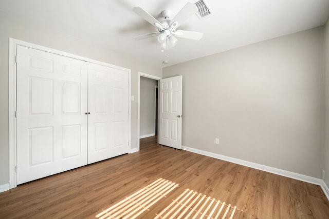 unfurnished bedroom featuring ceiling fan, wood-type flooring, and a closet