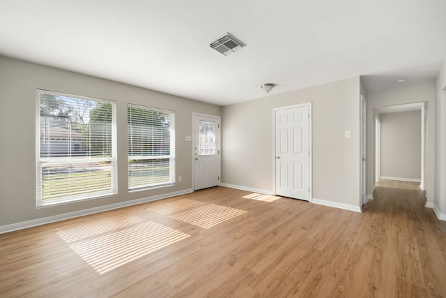 interior space featuring light wood-style floors, visible vents, plenty of natural light, and baseboards