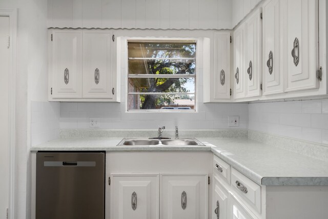 kitchen featuring stainless steel dishwasher, white cabinetry, sink, and tasteful backsplash