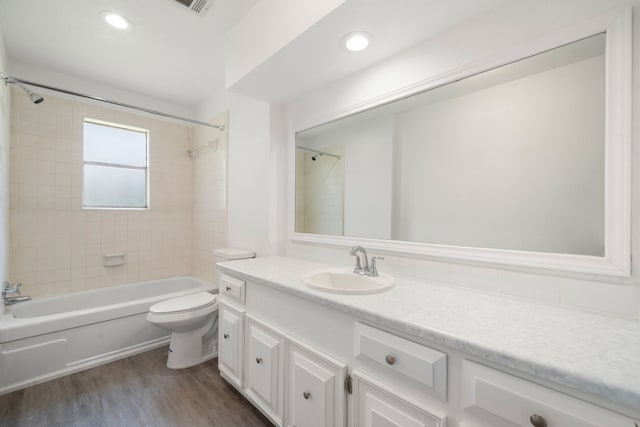 full bathroom with toilet, tiled shower / bath combo, vanity, and hardwood / wood-style flooring