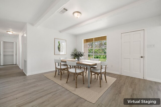 dining area with wood-type flooring and beam ceiling