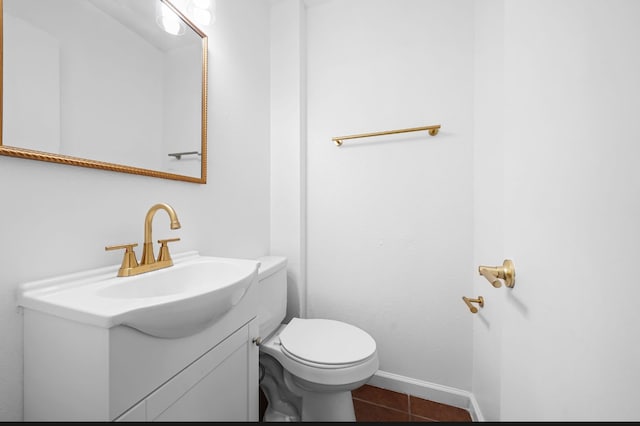 bathroom with toilet, vanity, and tile patterned floors