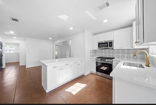 kitchen featuring kitchen peninsula, sink, white cabinets, and appliances with stainless steel finishes